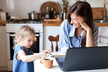 Woman working from home while watching child