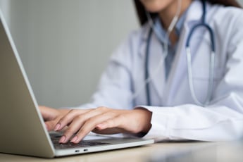 Doctor working on laptop for telemedicine appointment